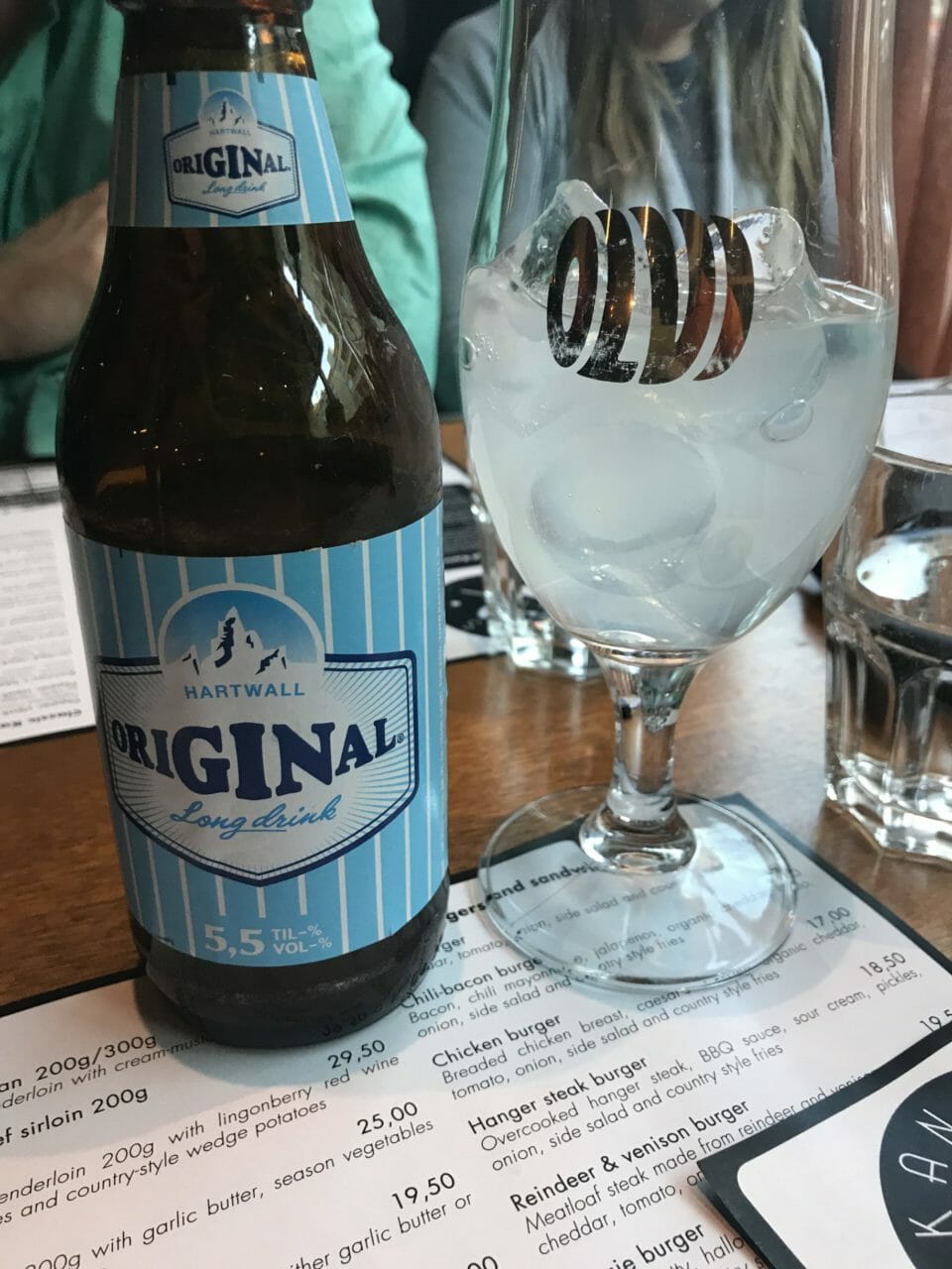 a bottle of beer next to a glass of ice