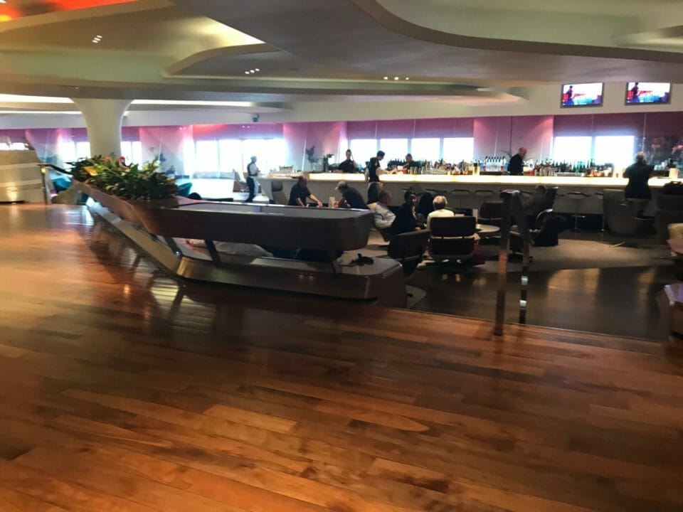a room with a bar and people sitting at the counter
