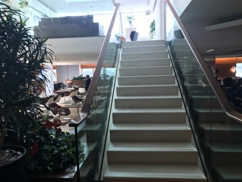 a staircase with glass railings and plants