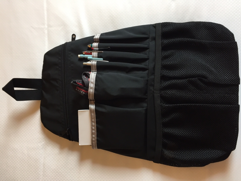 a black backpack with pens in it