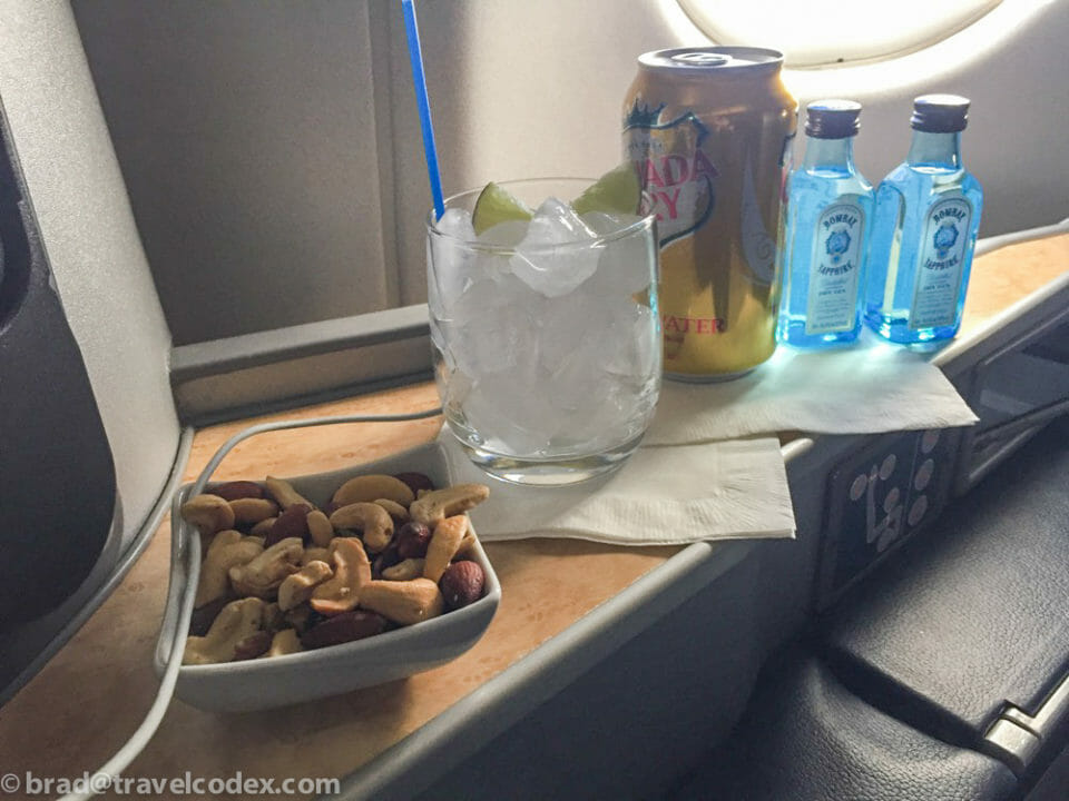 a bowl of nuts and a drink on a table