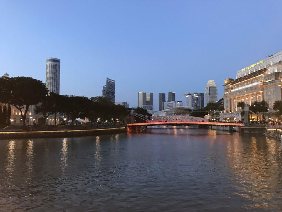 a river with a bridge and buildings in the background