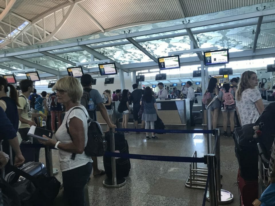 people in an airport with people standing in front of screens