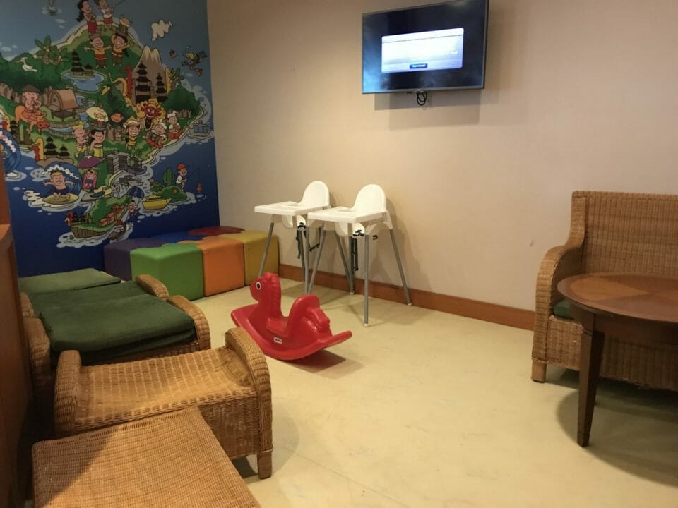 a room with a wall mural and chairs and a rocking horse