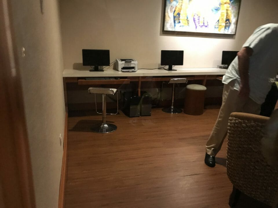 a man standing in a room with a desk and computer
