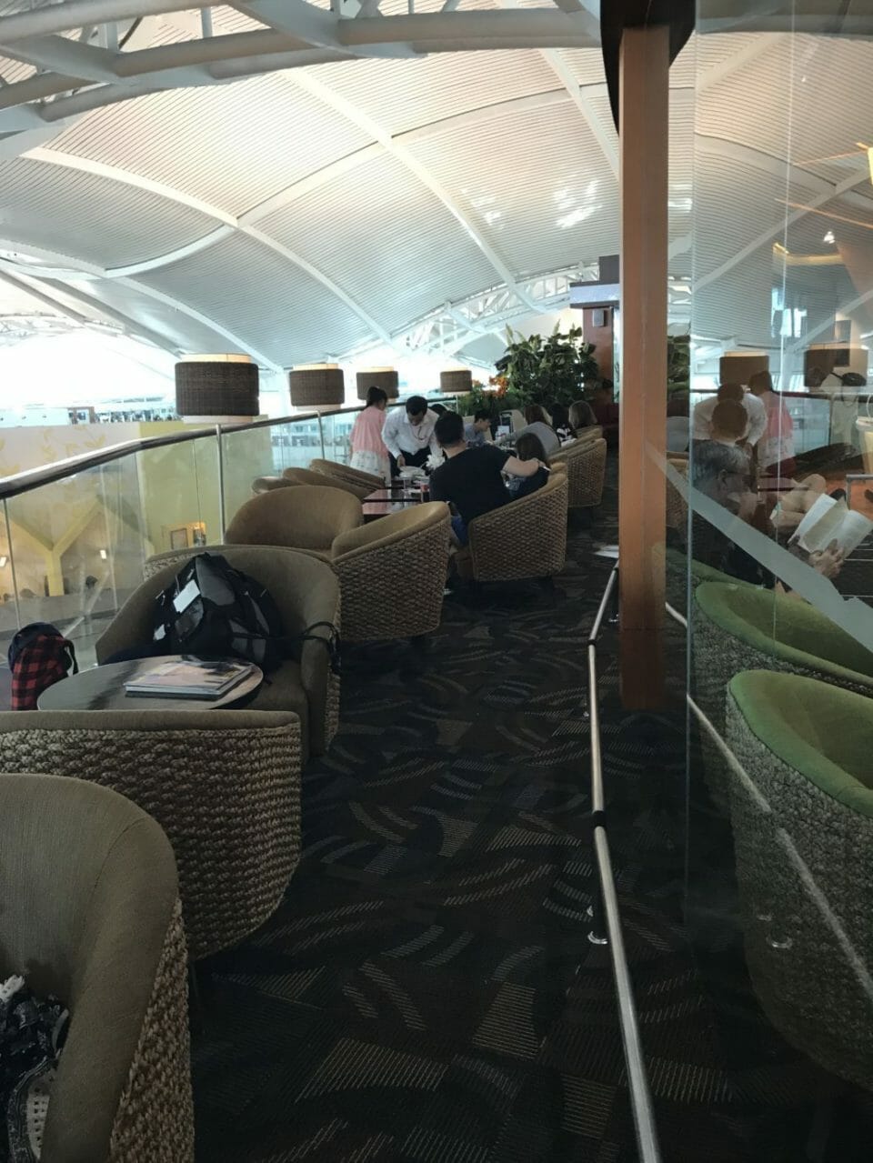 a group of people sitting in chairs in a room with glass walls