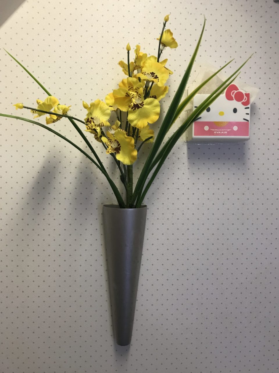 a yellow flowers in a silver vase