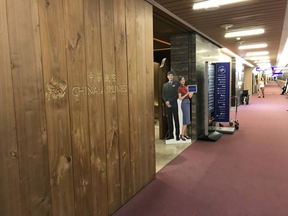 a wood paneled wall with a sign and a couple of people standing in the background