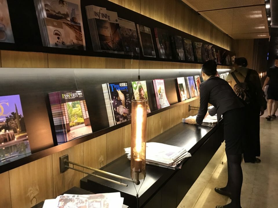a woman standing at a counter with magazines on it
