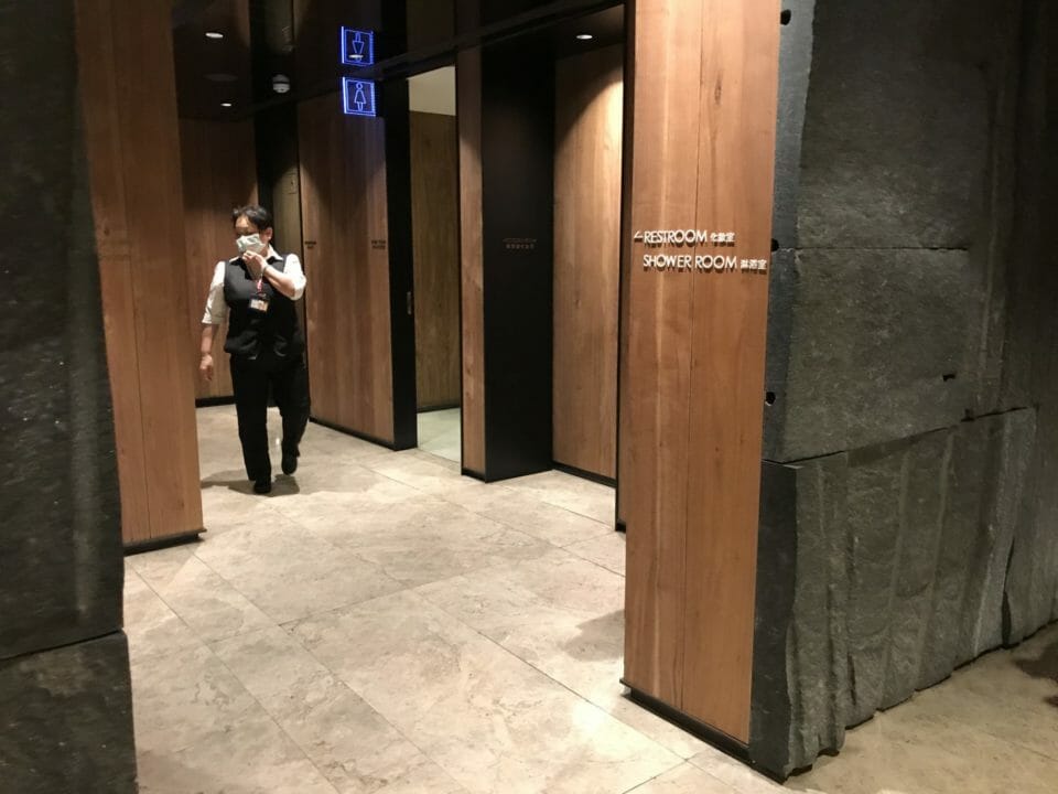 a man in a mask walking in a bathroom