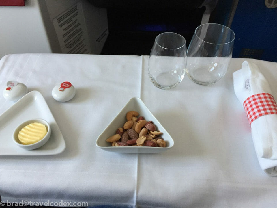 a plate of nuts and two glasses on a table