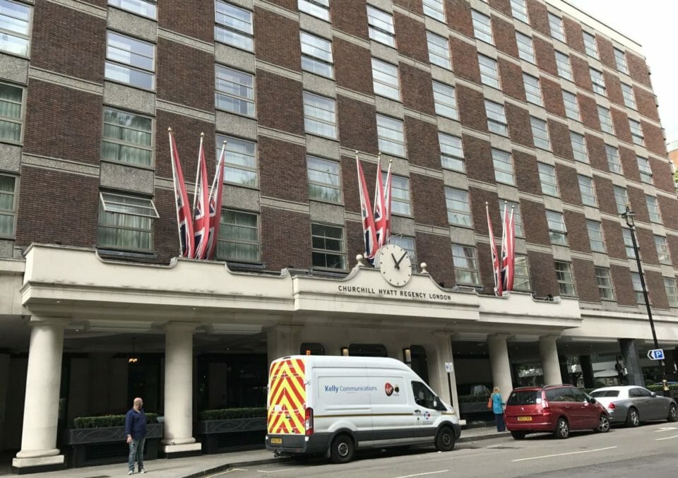 a building with a clock and flags on the front
