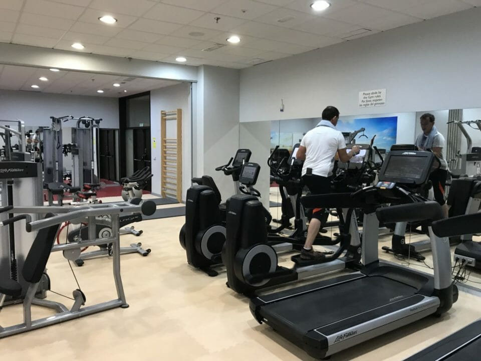 a man standing on treadmills in a gym