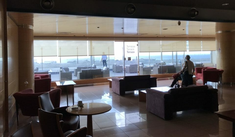 a room with a large window and chairs and tables