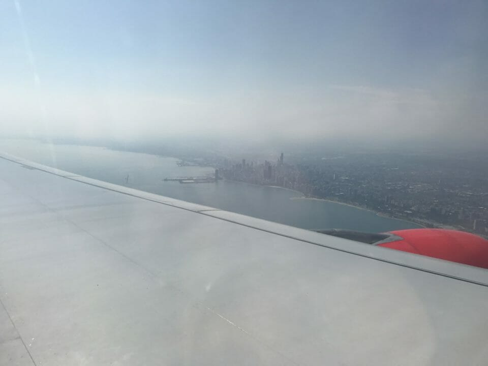an airplane wing with a city in the distance