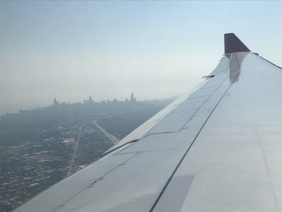 an airplane wing with a city in the background