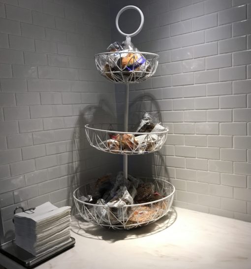 a three tiered basket with food in it