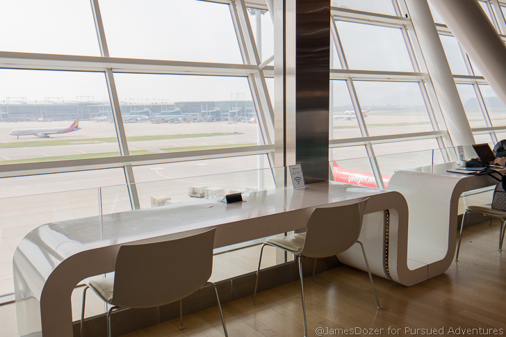 a white table and chairs in a room with large windows