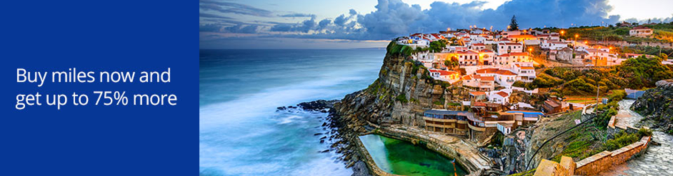 a body of water next to a cliff with houses on it