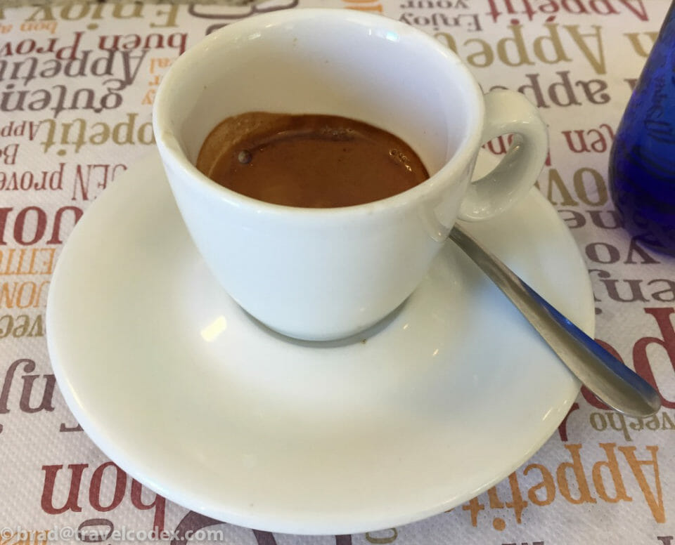 a cup of coffee on a saucer with a spoon
