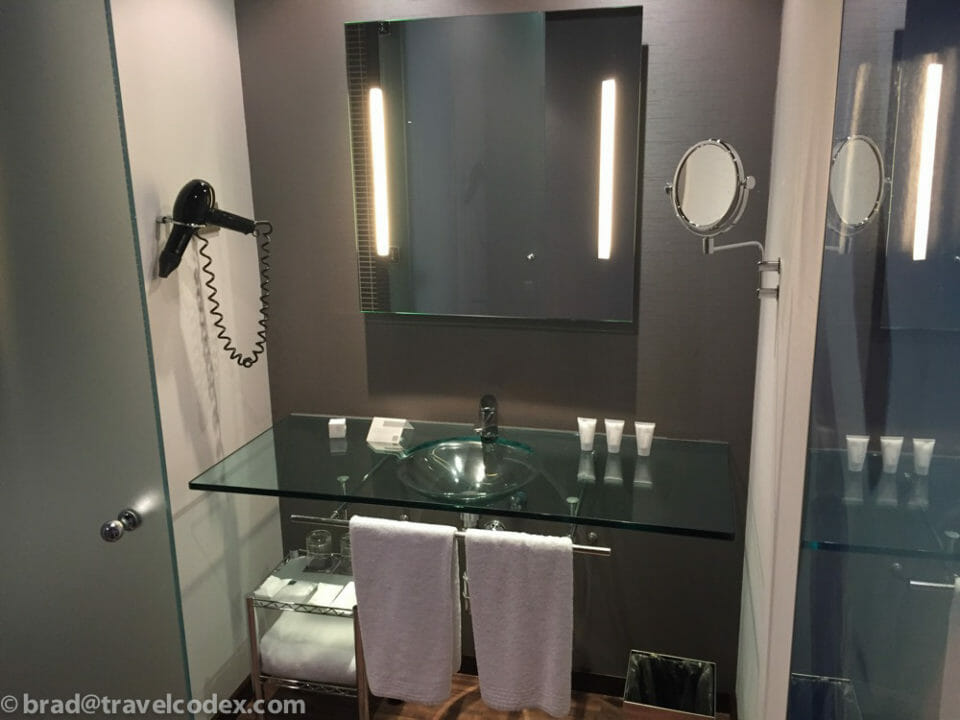 a bathroom with a glass sink and mirror