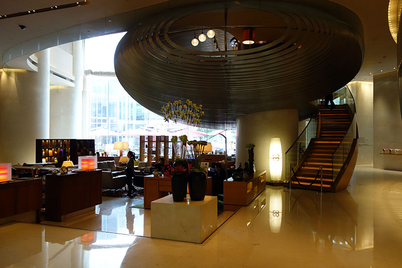a lobby with a staircase and a large ceiling