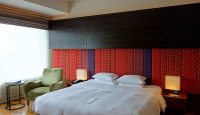 a bed with a lamp and a chair in a room