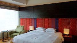 a bed with a lamp and a chair in a room