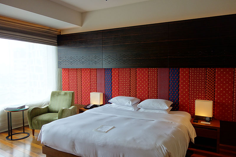a bed with a lamp and a chair in a room