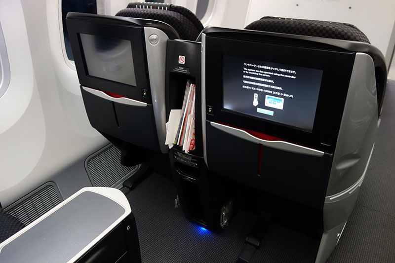 a tv and a screen on the side of a plane