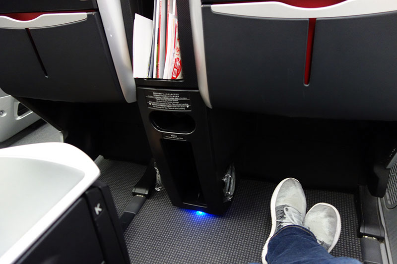 a person's feet in a blue light on the floor of an airplane