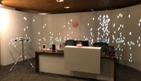 a desk with a white counter and a white screen with lights