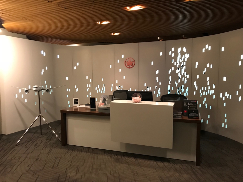 a desk with a white counter and a white screen with lights