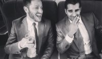 two men in suits sitting at a table