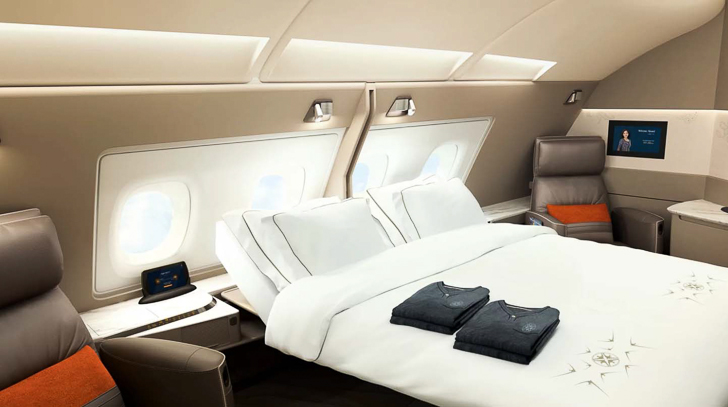 a bed with white sheets and pillows in an airplane