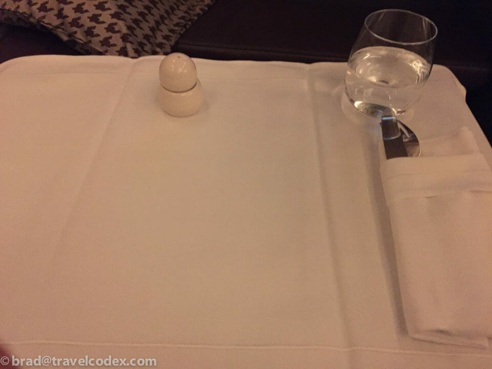 a salt shaker and a glass of water on a table