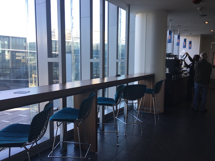a long table with chairs in a room with windows