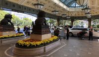 a group of people standing in a courtyard with a statue of a lion