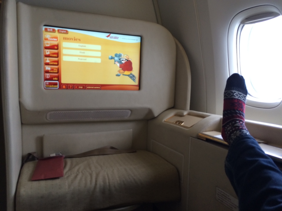 a person's feet on a television screen in a plane