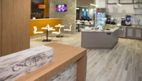 a restaurant with a wood counter and white chairs