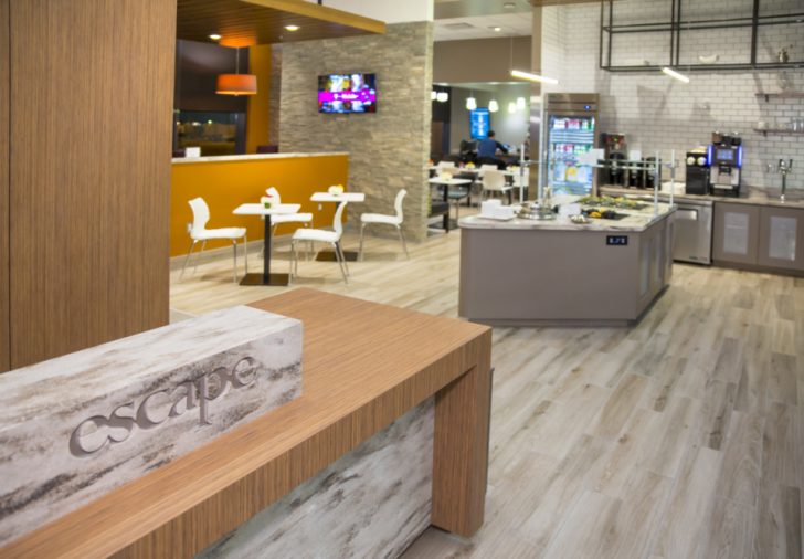 a restaurant with a wood counter and white chairs