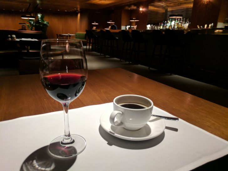 a glass of wine and a cup of coffee on a table
