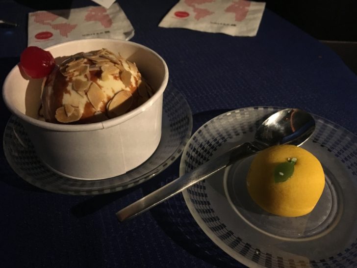 a bowl of ice cream and a fruit on a plate