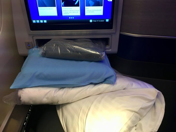 a bed with pillows and blankets on it