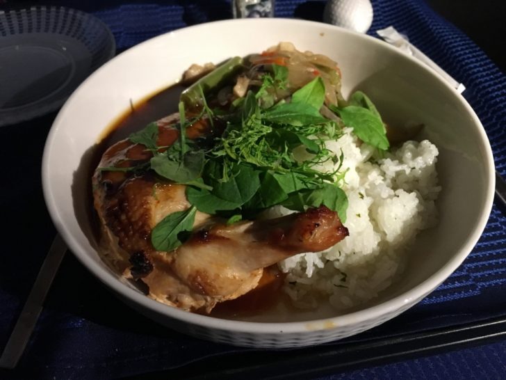 a bowl of food with chopsticks