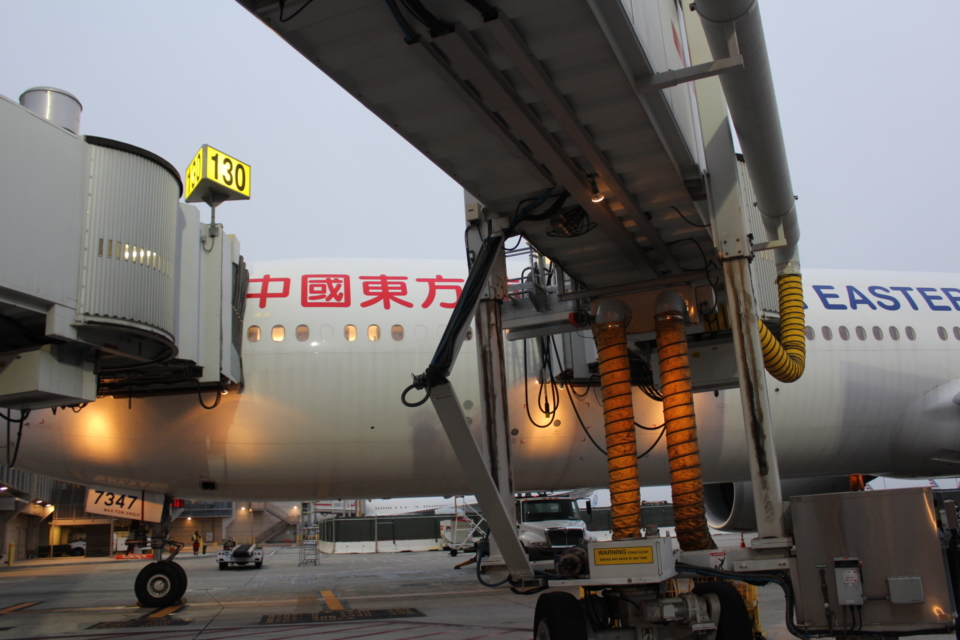a large white airplane with a yellow tube attached to it