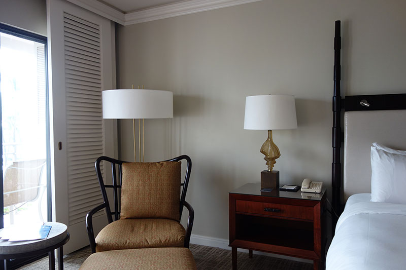 a bedroom with a chair and a lamp