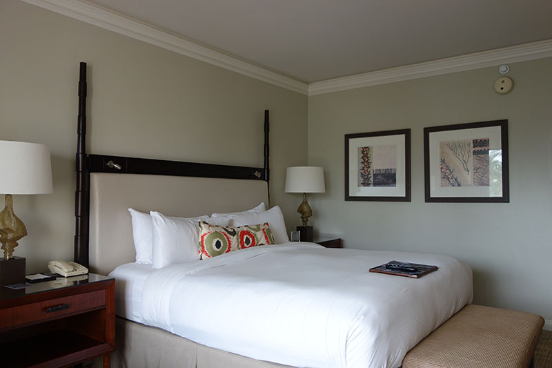 a bed with a white bedding and a lamp