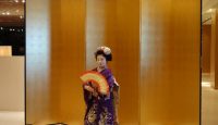a woman in a kimono holding a fan