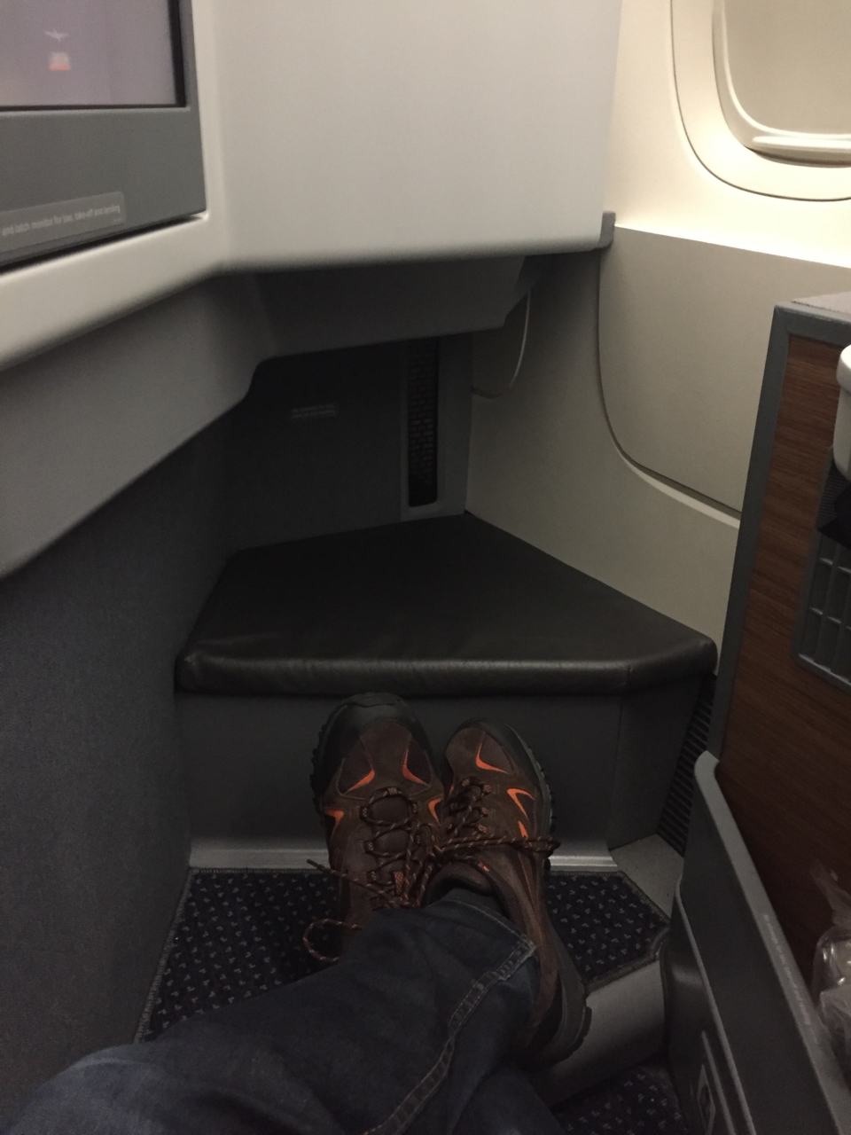 a person's feet in a seat on an airplane